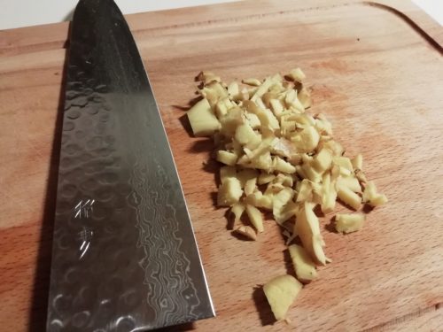 Un couteau japonais et du gingembre fraîchement coupé
