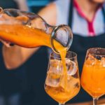 Un punch orange servi dans un verre à vin rempli de glaçons