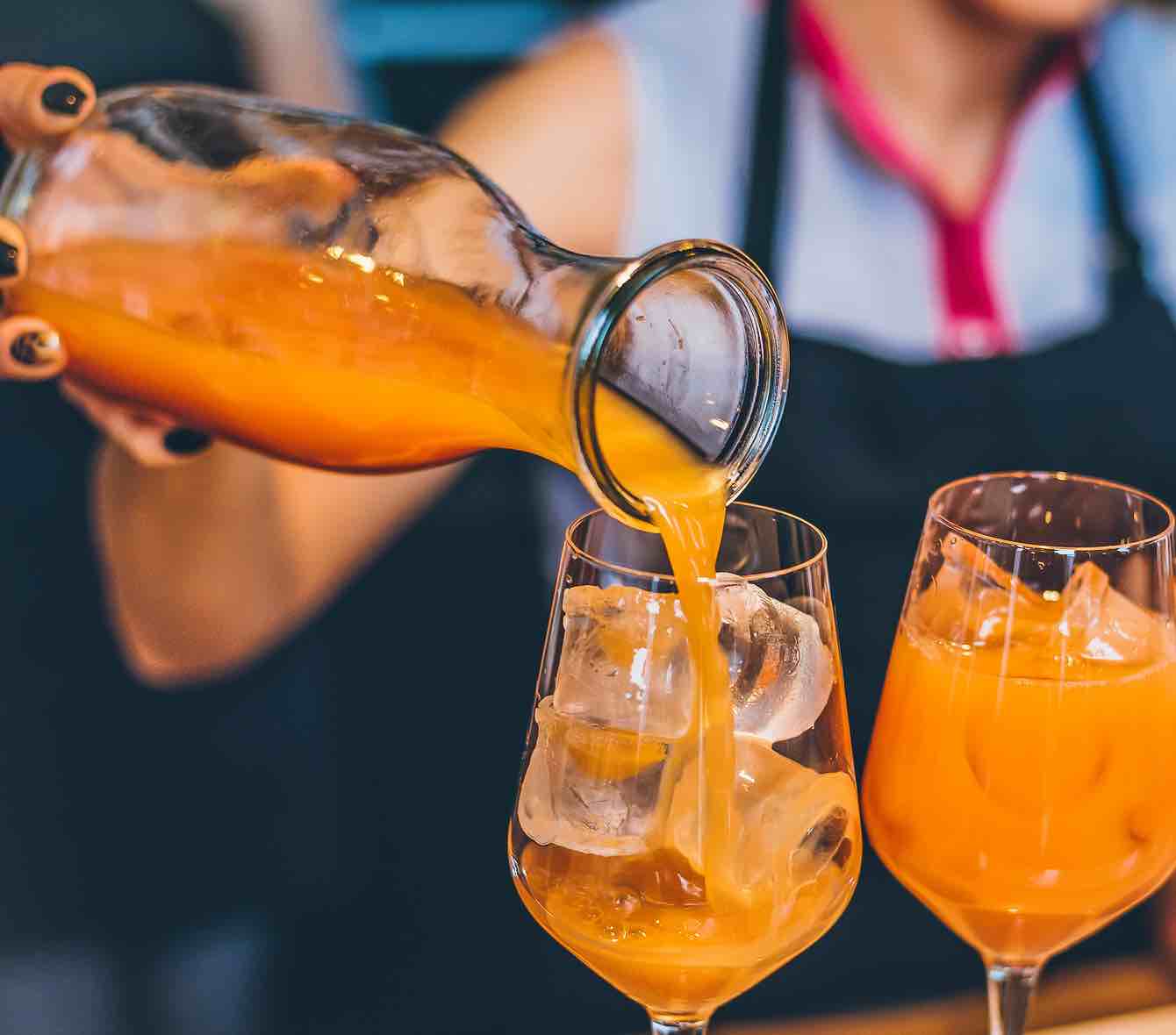 Un punch orange servi dans un verre à vin rempli de glaçons