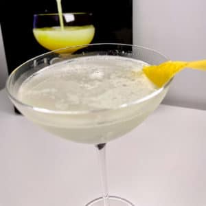 Un White Lady, garni d'un zeste de citron, un cocktail à base de gin, Cointreau et citron